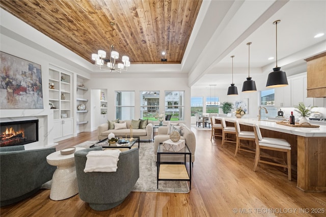 2607 E 135th Dr S, Bixby, OK 74008 - living room with wooden ceiling, a chandelier, light wood-style floors, built in shelves, and a raised ceiling