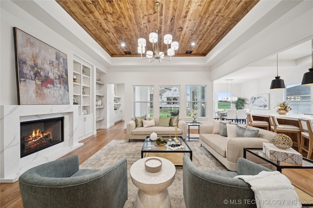 2607 E 135th Dr S, Bixby, OK 74008 - living area featuring a chandelier, wooden ceiling, built in shelves, wood finished floors, and a tray ceiling