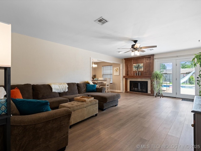 540 S Hamilton Ave, Dewey, OK 74029 - living room with ceiling fan, wood finished floors, a fireplace, and a chandelier