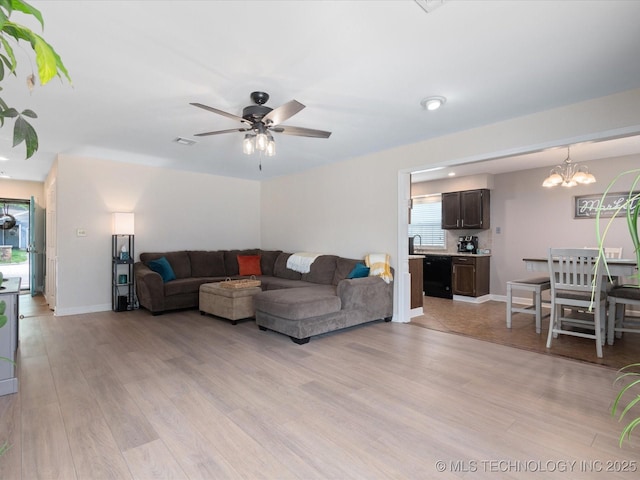 540 S Hamilton Ave, Dewey, OK 74029 - living area featuring light wood-style floors, a ceiling fan, a chandelier, and baseboards