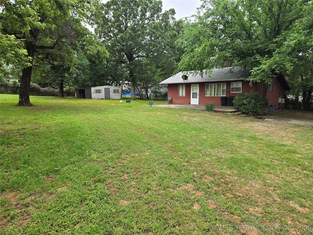 view of green lawn with a shed and an outdoor structure