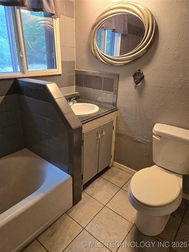 full bath with tile patterned floors, toilet, a bath, and vanity