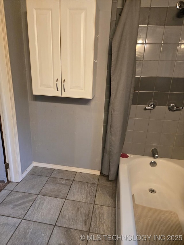 bathroom with baseboards, shower / bathtub combination with curtain, and tile patterned floors
