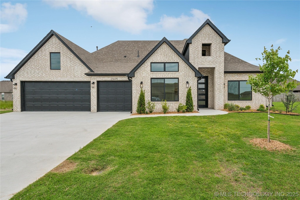 23079 E 106th Pl S, Broken Arrow, OK 74014 - view of front of home with roof with shingles, concrete driveway, a front lawn, and brick siding