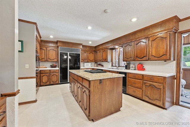 2956 E 69th St, Tulsa, OK 74136 - kitchen featuring black appliances, a center island, light countertops, brown cabinets, and ornamental molding