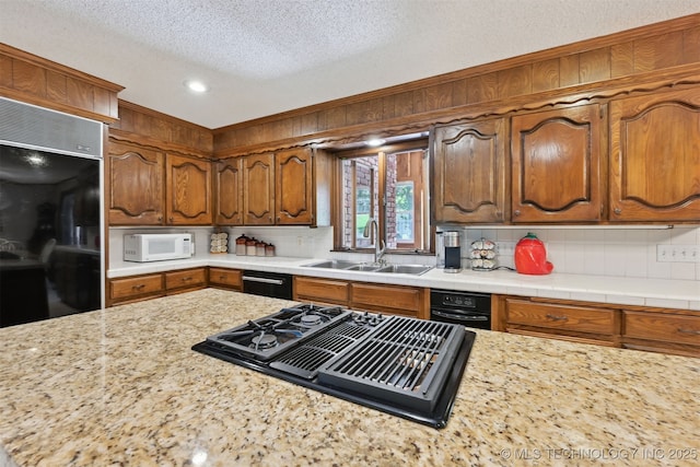 2956 E 69th St, Tulsa, OK 74136 - kitchen featuring black appliances, light countertops, decorative backsplash, a textured ceiling, and a sink