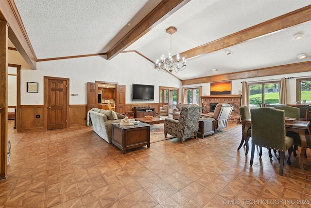 2956 E 69th St, Tulsa, OK 74136 - living room featuring a wainscoted wall, a chandelier, a textured ceiling, a fireplace, and crown molding