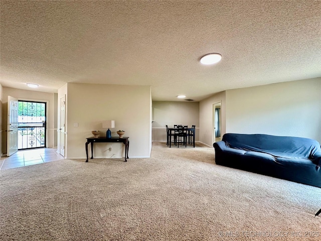 living area featuring carpet flooring, a textured ceiling, and baseboards