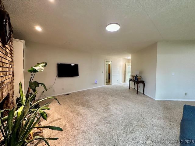unfurnished living room featuring a textured ceiling, carpet, baseboards, and a fireplace