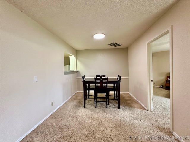 dining area with carpet flooring, a textured ceiling, and baseboards