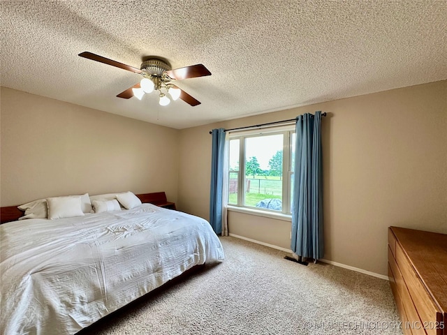 bedroom featuring carpet, a textured ceiling, a ceiling fan, and baseboards