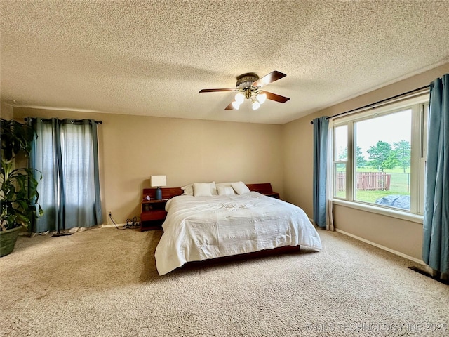 carpeted bedroom featuring a textured ceiling, a ceiling fan, and baseboards