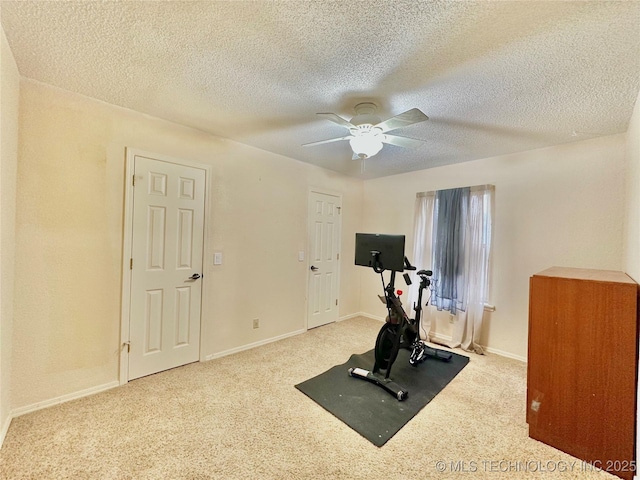 exercise room featuring ceiling fan, carpet floors, a textured ceiling, and baseboards