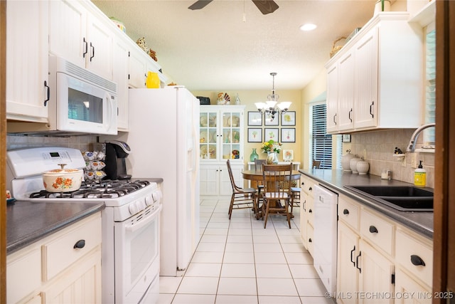 15919 E 79th St N, Owasso, OK 74055 - kitchen featuring white appliances, a sink, dark countertops, decorative backsplash, and light tile patterned flooring