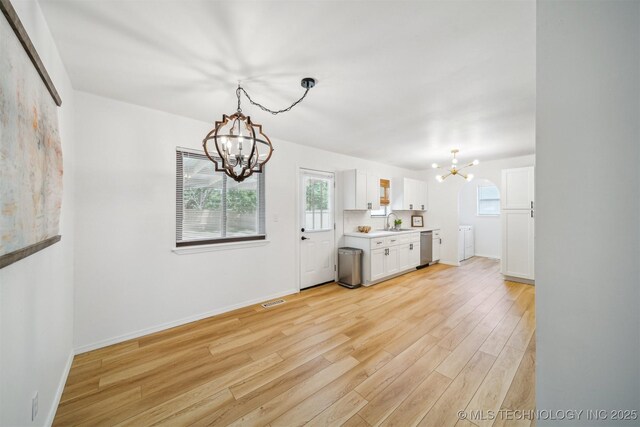 1010 S Wewoka Ave, Claremore, OK 74017 - kitchen featuring a chandelier, a sink, light wood-style floors, white cabinets, and stainless steel dishwasher