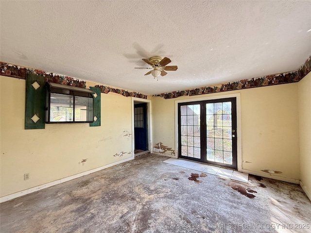unfurnished room featuring a textured ceiling, ceiling fan, baseboards, concrete flooring, and french doors