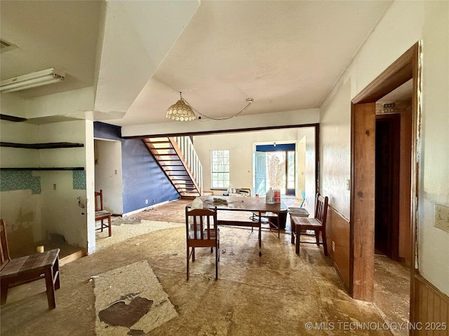 dining area with stairs and wainscoting