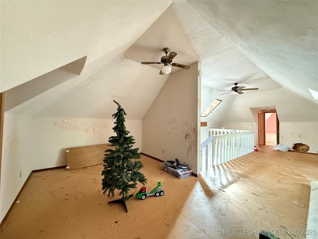 additional living space featuring ceiling fan, a textured ceiling, and lofted ceiling