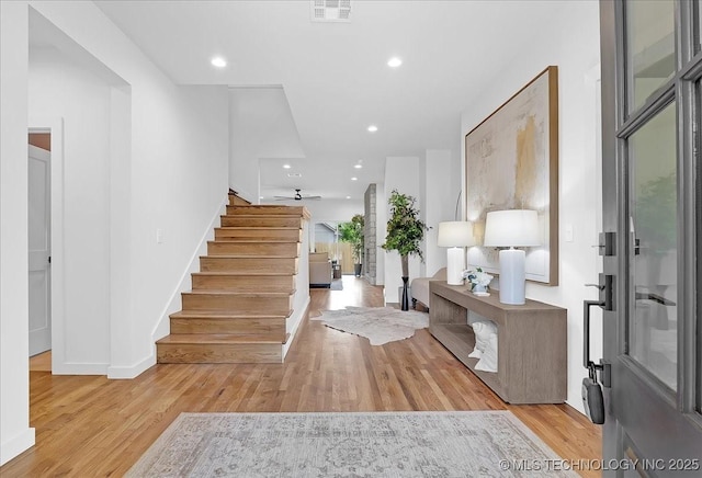 entryway featuring stairway, baseboards, light wood finished floors, and recessed lighting