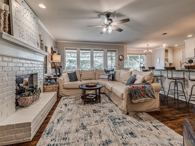 5517 E 101st Pl, Tulsa, OK 74137 - living area featuring a ceiling fan, dark wood-type flooring, ornamental molding, a fireplace, and a chandelier