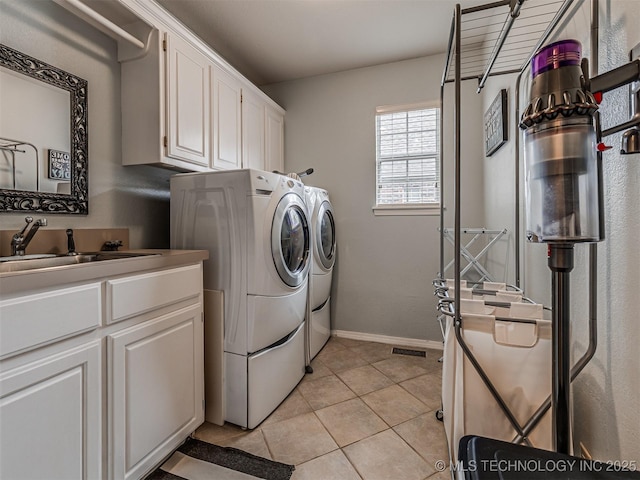 5517 E 101st Pl, Tulsa, OK 74137 - laundry room with washing machine and clothes dryer, cabinet space, light tile patterned floors, and baseboards