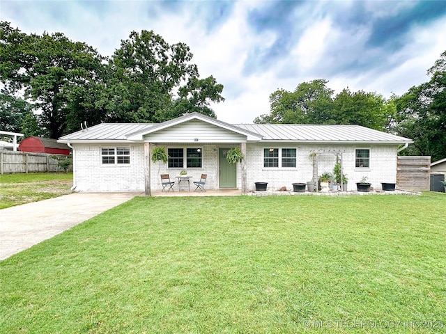 602 S Elm St, Muldrow, OK 74948 - view of front facade featuring a standing seam roof, brick siding, metal roof, driveway, and central AC
