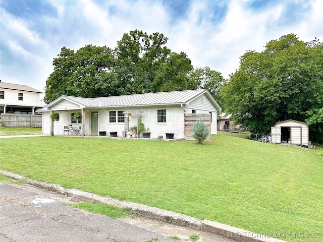 602 S Elm St, Muldrow, OK 74948 - view of front of house featuring a standing seam roof, a storage unit, an outdoor structure, brick siding, and metal roof