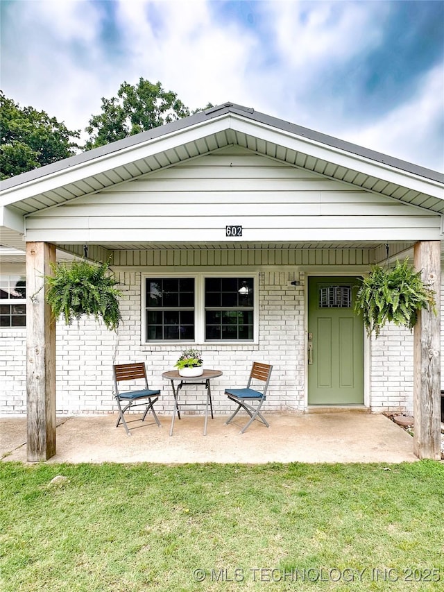 602 S Elm St, Muldrow, OK 74948 - rear view of property featuring brick siding and a yard