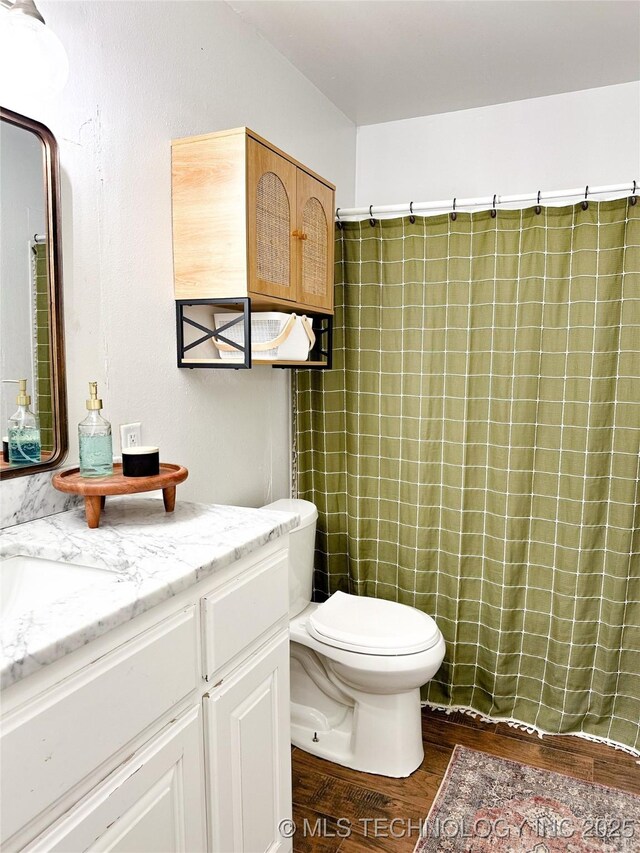 602 S Elm St, Muldrow, OK 74948 - bathroom featuring wood finished floors, vanity, toilet, and a shower with shower curtain