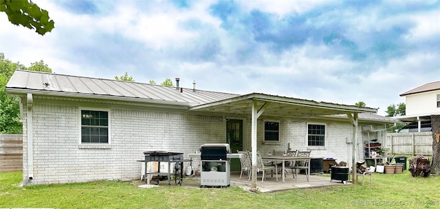 602 S Elm St, Muldrow, OK 74948 - back of property with a patio, brick siding, and metal roof
