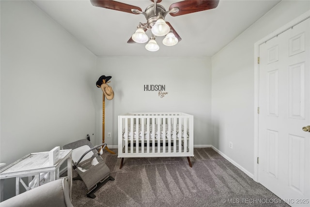 carpeted bedroom featuring baseboards, a ceiling fan, and a nursery area