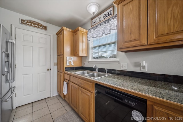 kitchen with black dishwasher, a sink, stainless steel fridge, light tile patterned flooring, and brown cabinetry