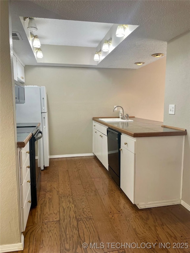 3164 S 101st E Ave Unit 801, Tulsa, OK 74146 - kitchen with a sink, black appliances, dark wood finished floors, white cabinetry, and baseboards