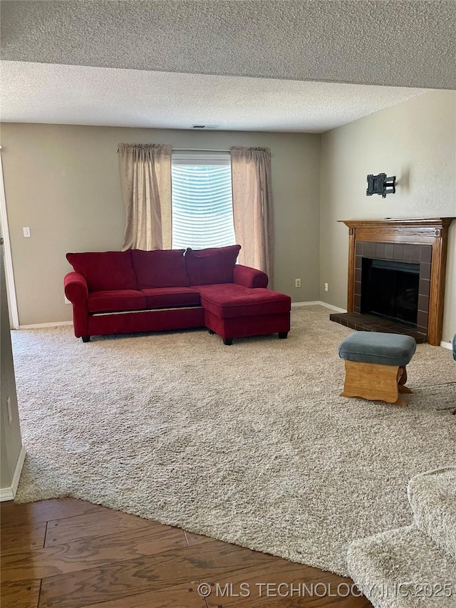 3164 S 101st E Ave Unit 801, Tulsa, OK 74146 - living area featuring carpet floors, a fireplace, baseboards, and a textured ceiling