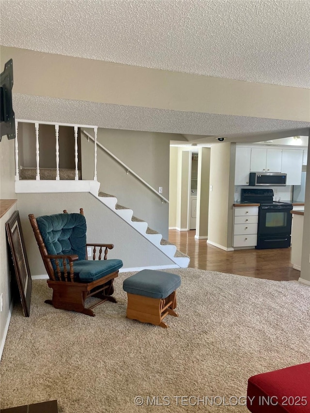 3164 S 101st E Ave Unit 801, Tulsa, OK 74146 - living area with carpet floors, a textured ceiling, baseboards, and stairs