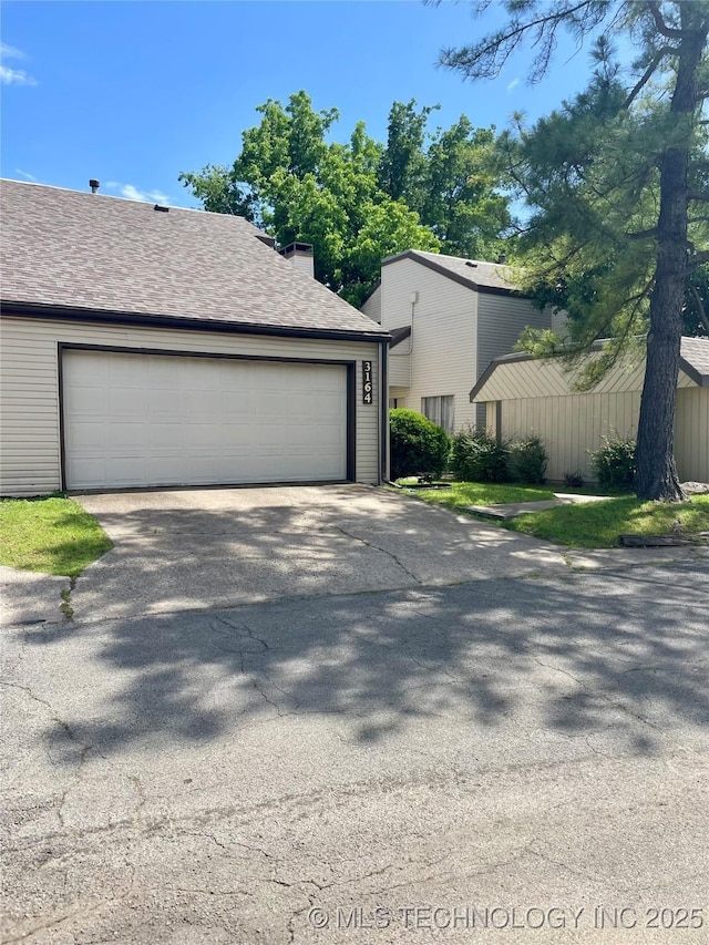 3164 S 101st E Ave Unit 801, Tulsa, OK 74146 - view of front facade featuring a garage and roof with shingles
