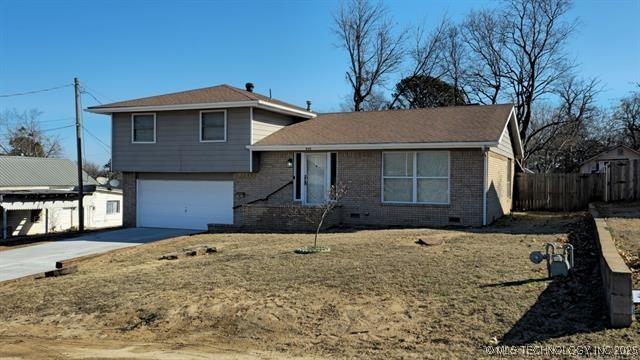 411 S 3rd, Eufaula, OK 74432 - split level home with fence, driveway, an attached garage, and brick siding