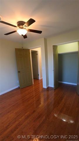 411 S 3rd, Eufaula, OK 74432 - unfurnished bedroom with baseboards, wood finished floors, and a ceiling fan
