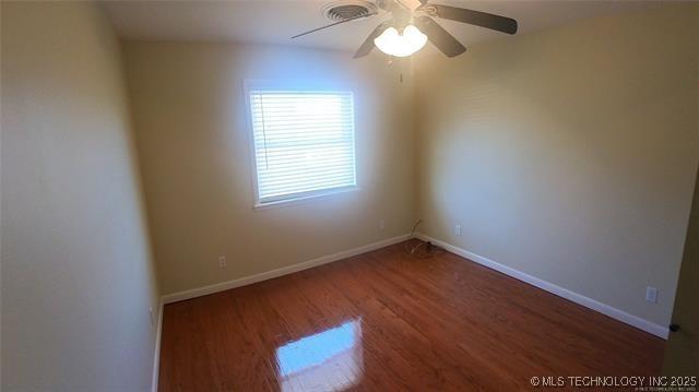 411 S 3rd, Eufaula, OK 74432 - empty room featuring wood finished floors, ceiling fan, and baseboards