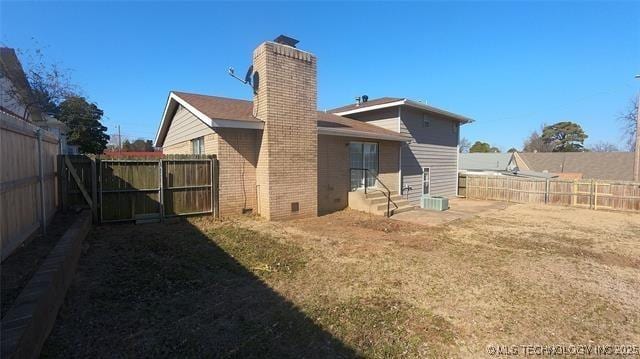 411 S 3rd, Eufaula, OK 74432 - back of house featuring a chimney, a fenced backyard, brick siding, and entry steps