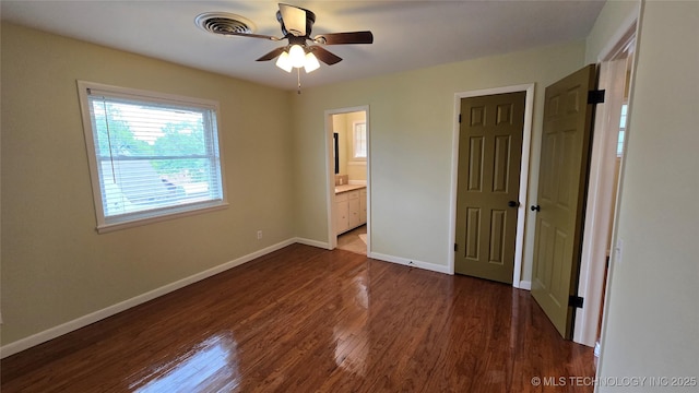 411 S 3rd, Eufaula, OK 74432 - unfurnished bedroom featuring baseboards, dark wood-style flooring, and connected bathroom
