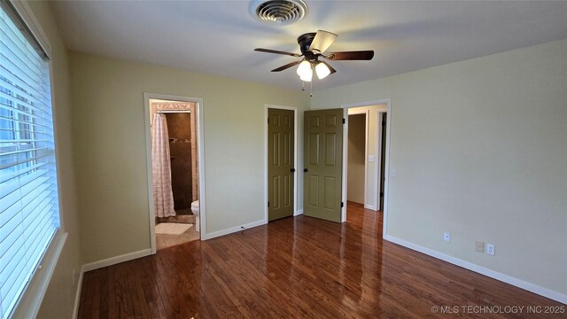 411 S 3rd, Eufaula, OK 74432 - unfurnished bedroom with wood finished floors, baseboards, ensuite bathroom, and ceiling fan