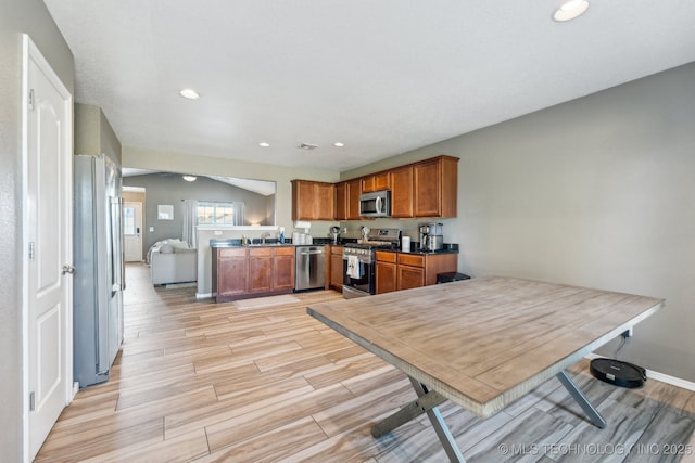 11088 N 116th E Ave, Owasso, OK 74055 - kitchen with stainless steel appliances, light wood finished floors, brown cabinetry, recessed lighting, and dark countertops