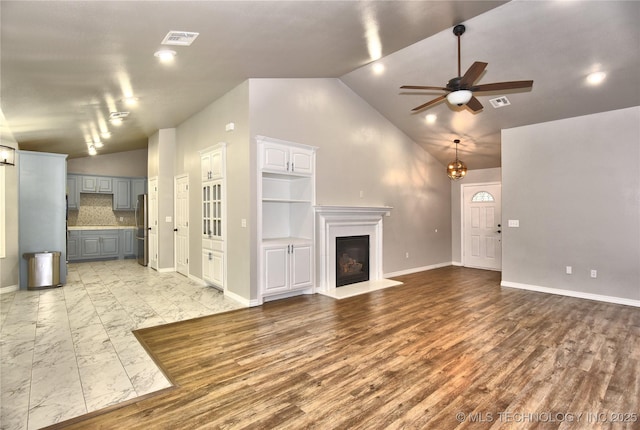 119 N 6th Mile, Fort Gibson, OK 74434 - unfurnished living room featuring lofted ceiling, ceiling fan, a glass covered fireplace, baseboards, and a chandelier