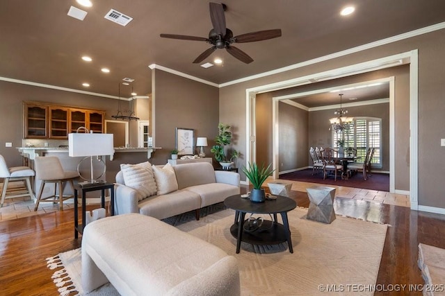 living room with wood finished floors, crown molding, recessed lighting, baseboards, and a chandelier