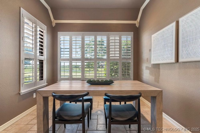 dining room featuring baseboards, crown molding, a textured wall, and stone finish flooring