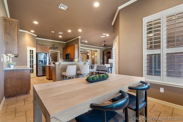 dining area with ornamental molding, recessed lighting, stone tile flooring, baseboards, and a ceiling fan