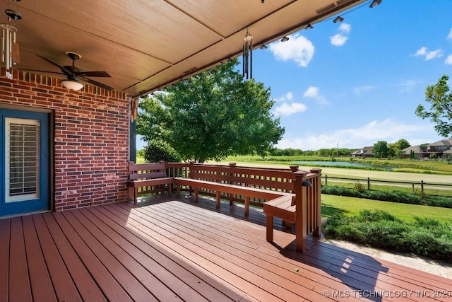 wooden deck with a ceiling fan and a water view