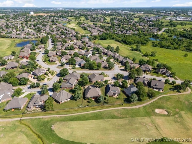 aerial view of property's location with a golf course, nearby suburban area, and a large body of water