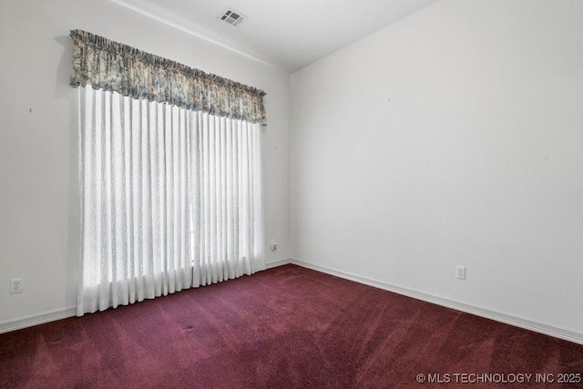 spare room featuring carpet and baseboards